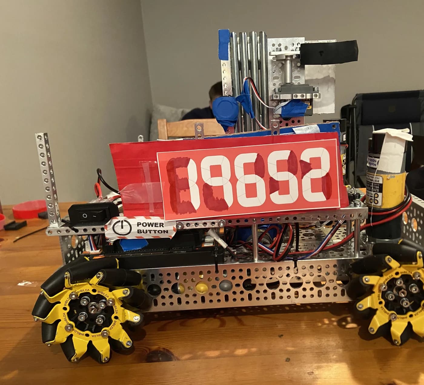 Rob-Ot on a workbench with its red 19652 plate and yellow mecanum wheels